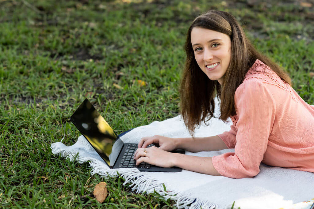 Caitlyn Well, owner of Upwell Strategies working on her laptop. Caitlyn helped the business owner in this case study pivot her business and find her purpose again. 