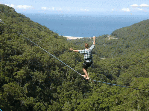 Man walking on a high-line rope, wobbling as he is trying to balance. This is how we imagine CEOs dealing with tough team capacity planning. 